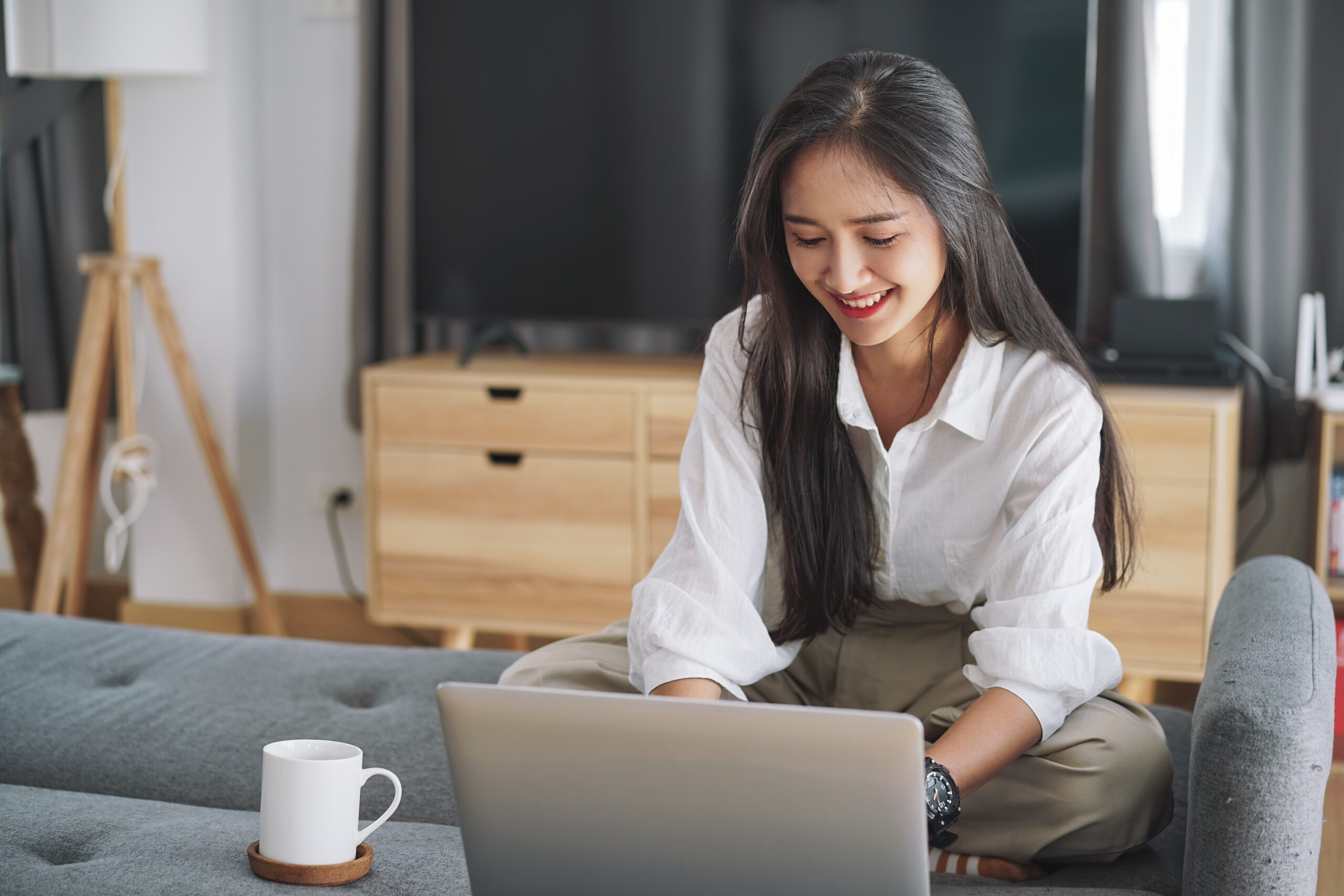 Attractive asian businesswoman working with laptop computer in living room at her home. Working at home concept