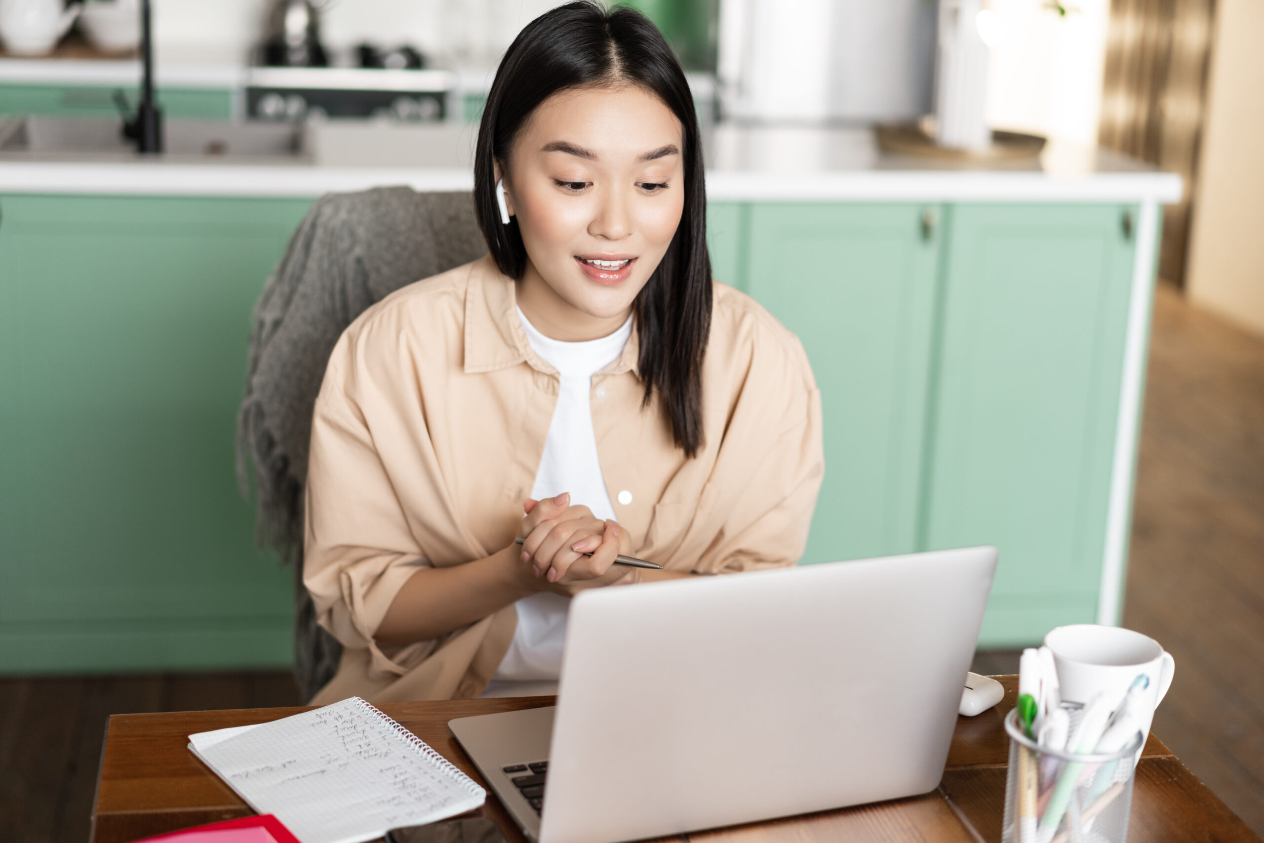 Young corporate woman working from home. Asian girl has online classes remotely, talking on video chat, internet lecture or webinar